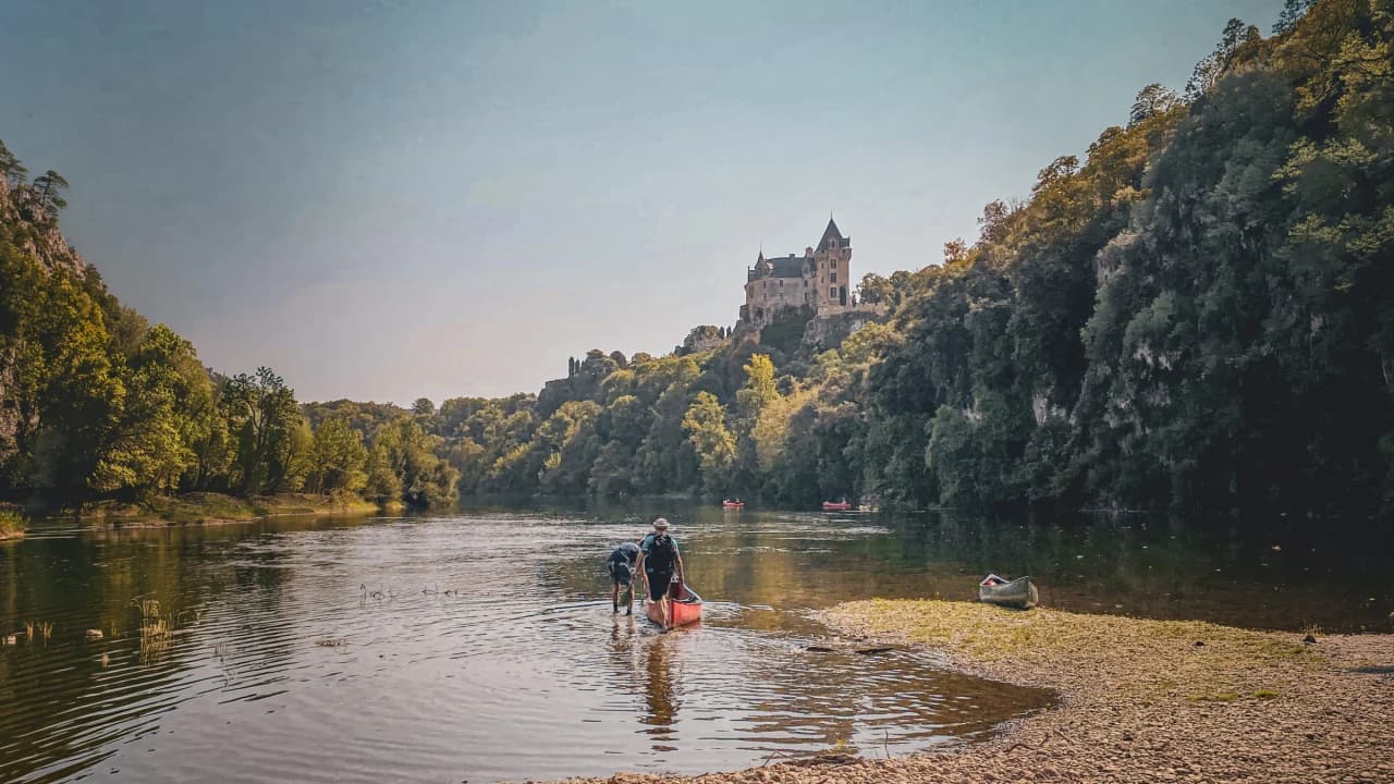 Voyagez en Dordogne : canoë sur la rivière, châteaux majestueux et nature verdoyante.