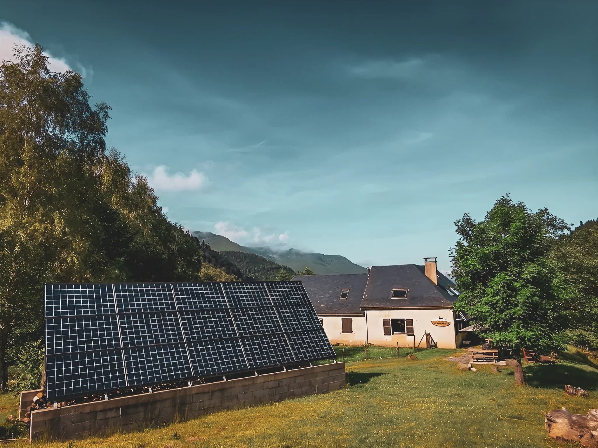 Een pittoresk berghuis met zonnepanelen, omgeven door weelderig groen.