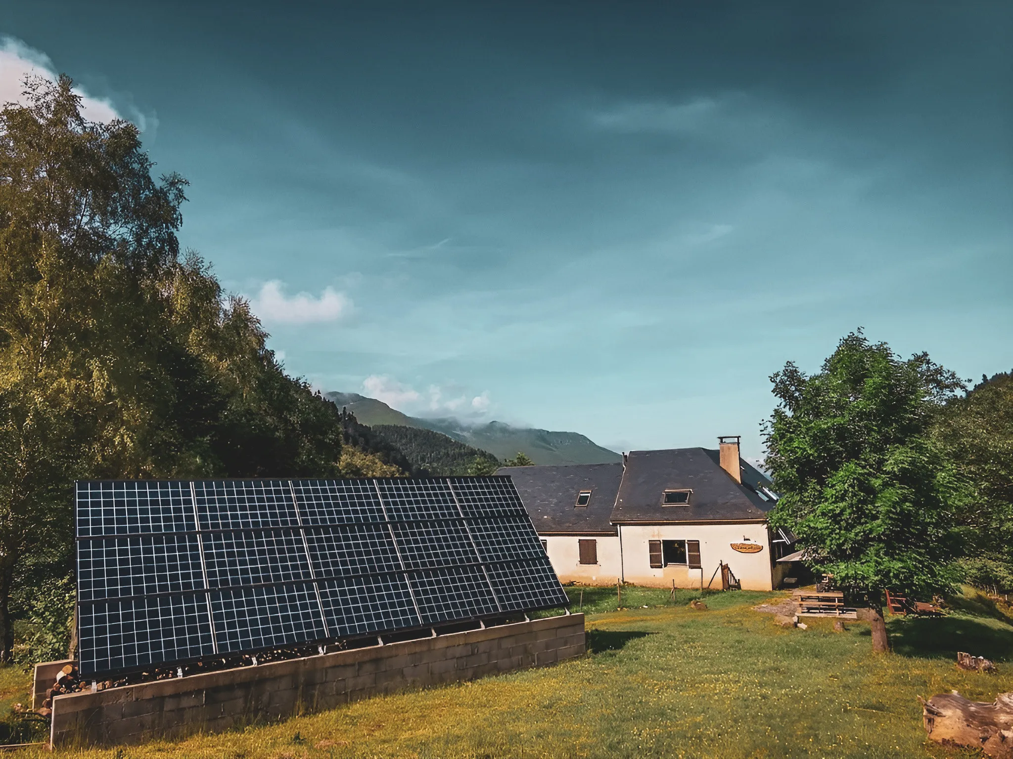 Een pittoresk berghuis met zonnepanelen, omgeven door weelderig groen.