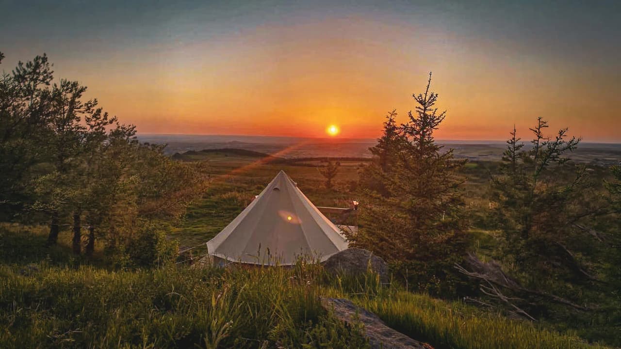 Tent op de top van een pas, kijkend naar de zonsondergang over het Centraal Massief. Ontsnapping aan de natuur gegarandeerd!