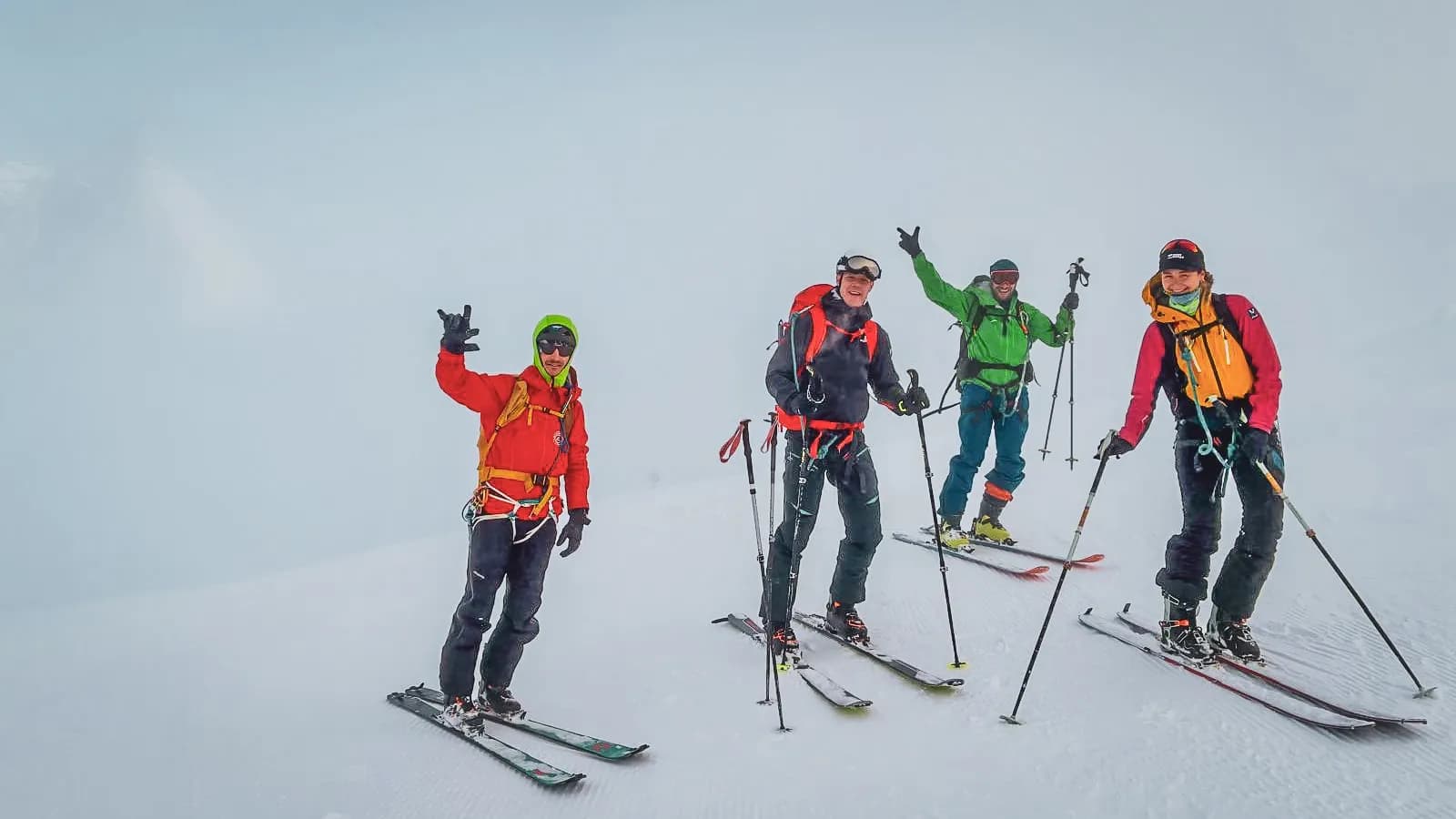 Quatre skieurs souriants en montagne, prêts pour l'aventure sur les glaciers du Mont Rose.