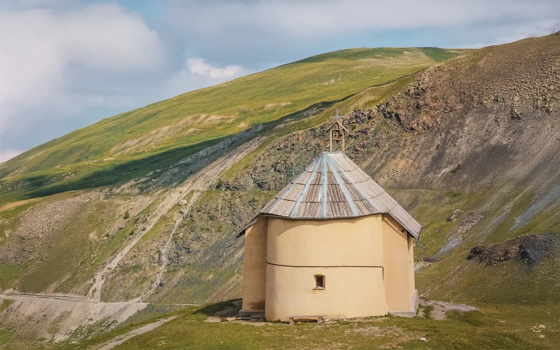 Charming rotunda at altitude, surrounded by green hills and majestic mountains.