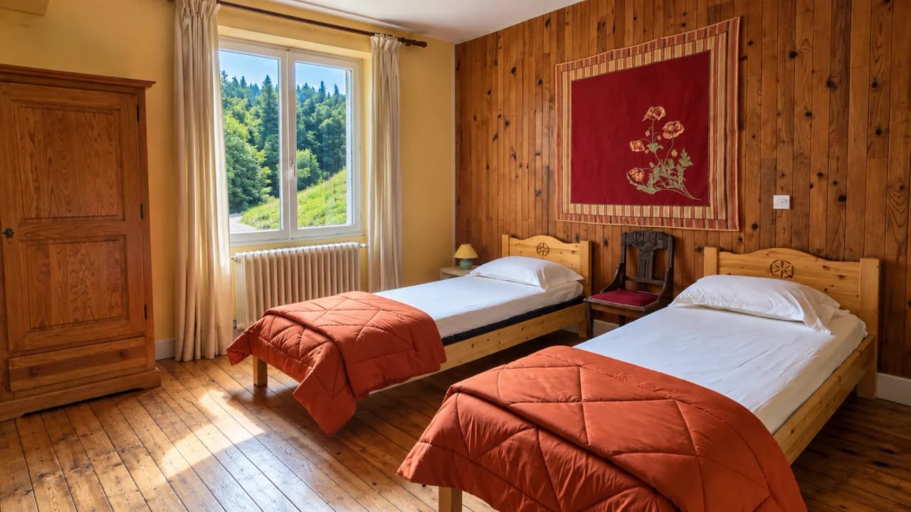 Chambre accueillante avec lits simples, offrant une vue apaisante sur la nature environnante.