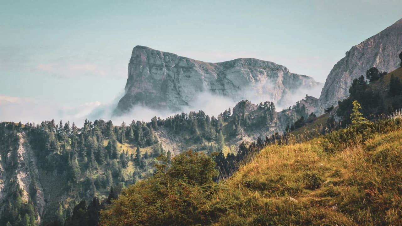 Montagnes majestueuses enveloppées de brume, invites à l'évasion dans le Vercors.