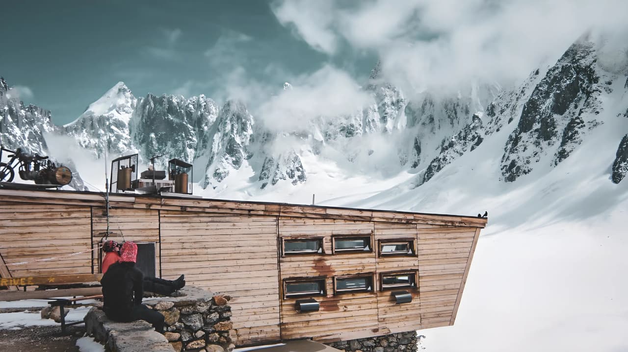 Wooden hut in the heart of the Mont Blanc glaciers, surrounded by majestic peaks and snow.
