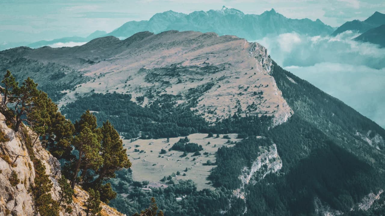 Panoramic view of the Vercors High Plateaux, lush green meadows and majestic ridges.