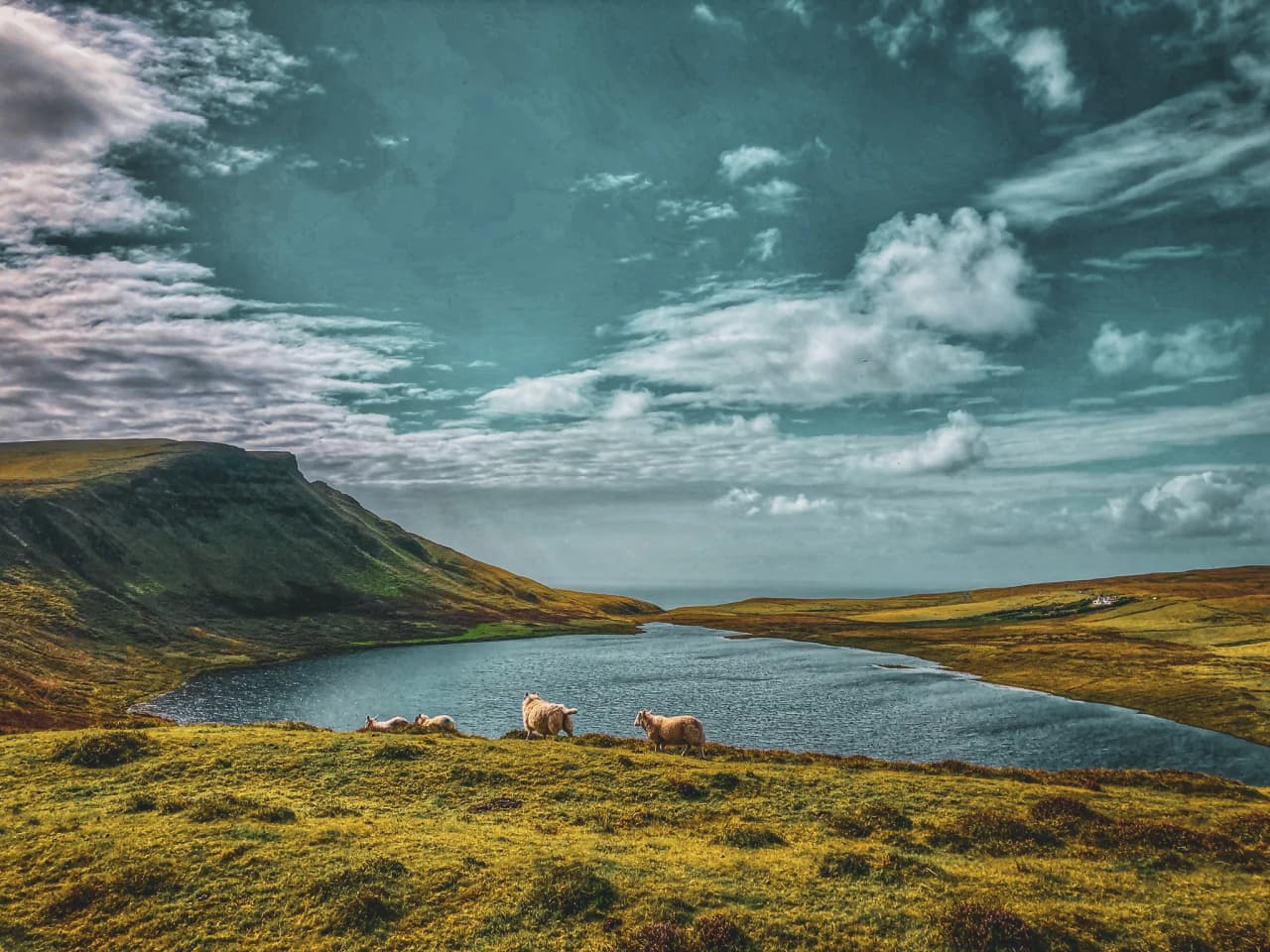 Paysages majestueux de l'île de Skye, avec des collines verdoyantes et un lac serein.