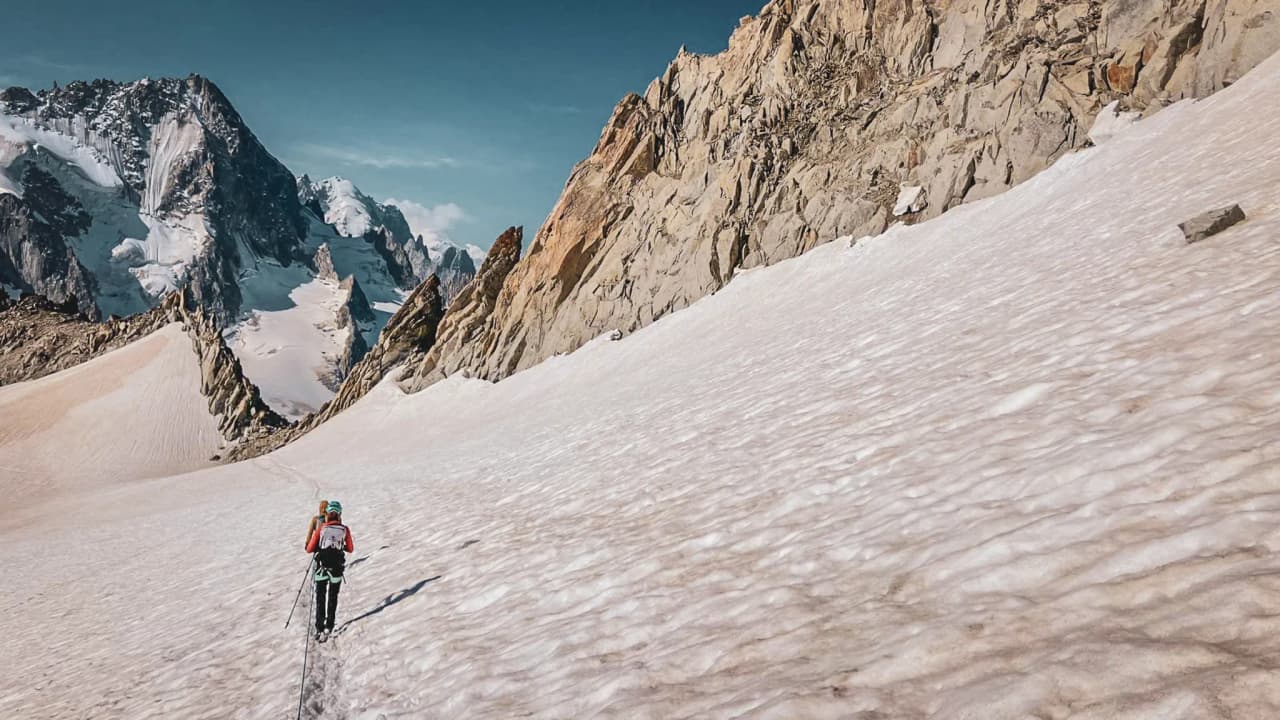 Un alpiniste s'aventure sur un glacier, entouré de sommets majestueux à Chamonix.