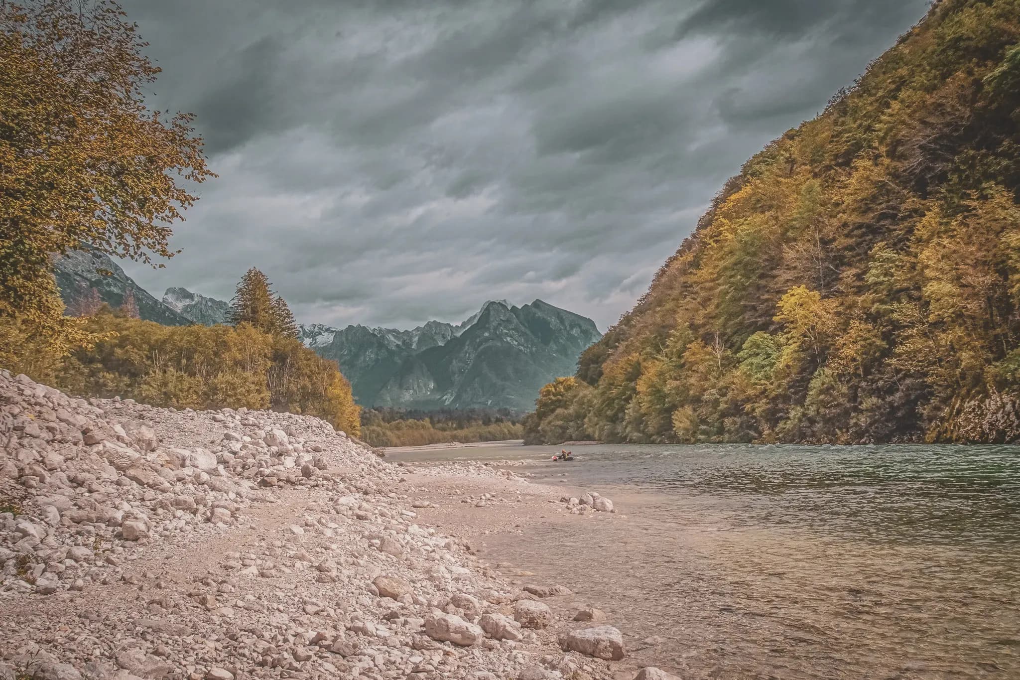 A soothing river surrounded by majestic mountains and autumn foliage, an invitation to adventure.