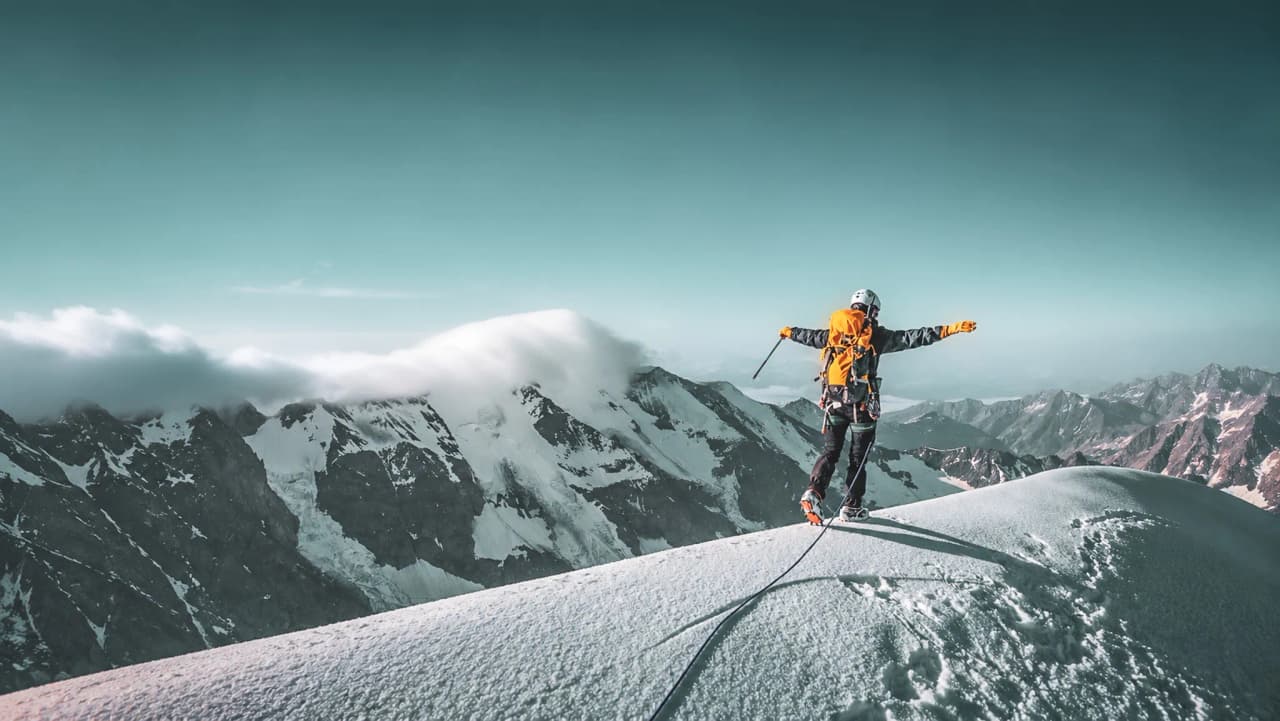 Hoge gletsjerpiek, klimmer balancerend onder een blauwe hemel, adembenemend panorama van de Dômes de Miage.