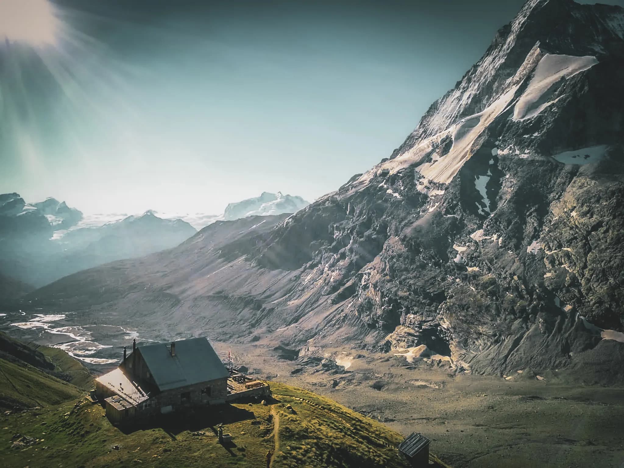 Spectacular panoramic view of majestic mountains overlooking an alpine mountain hut.