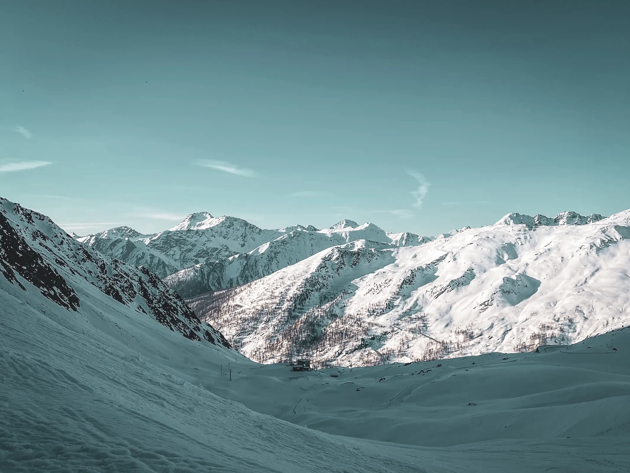 Panorama alpin éblouissant au col du Grand-Saint-Bernard, neige immaculée et sommets majestueux.