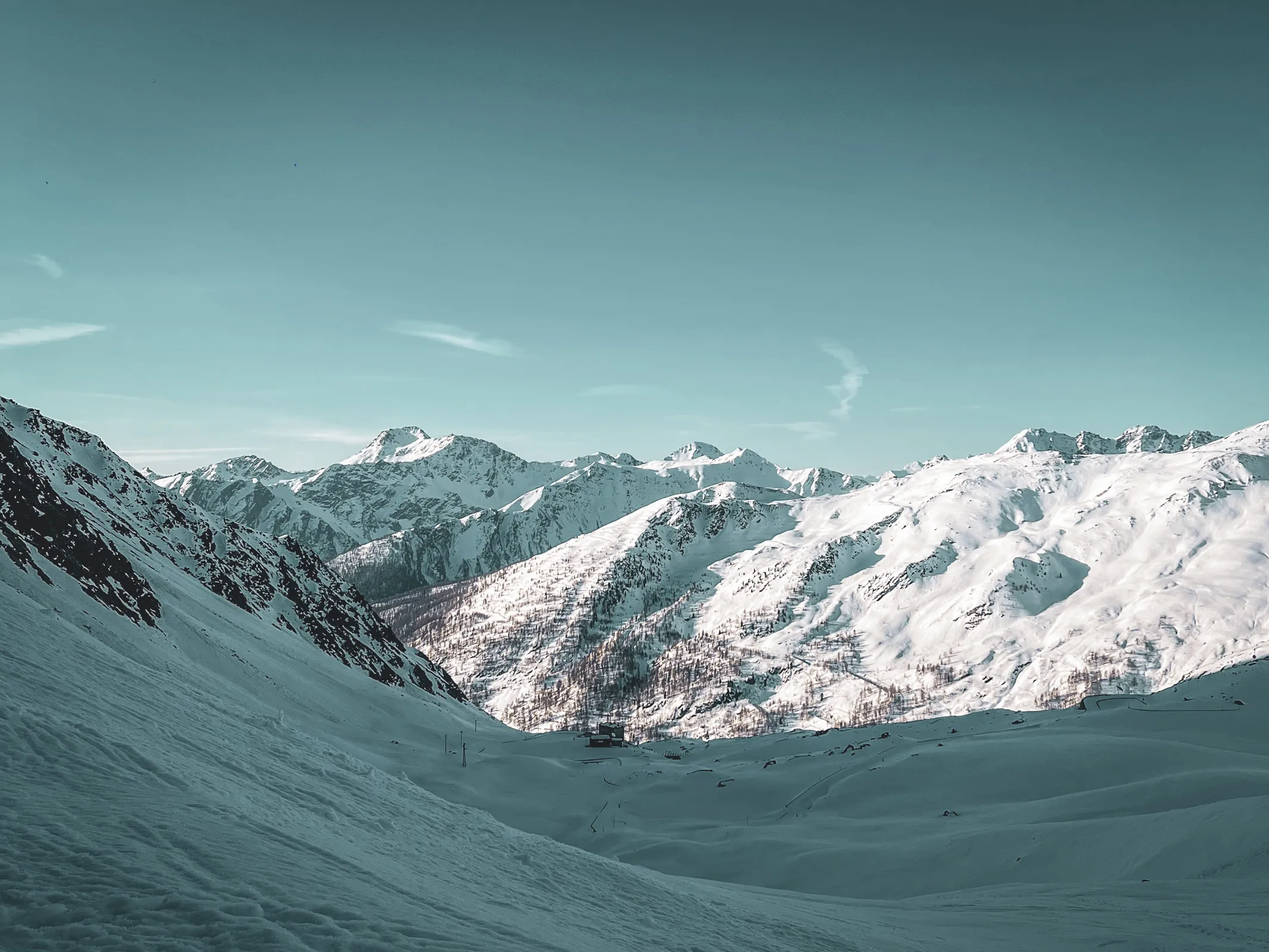 Panorama alpin éblouissant au col du Grand-Saint-Bernard, neige immaculée et sommets majestueux.