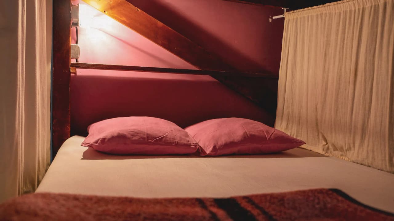 Een gezellige kamer met roze bedden en kussens, ideaal om te ontspannen na een alpien avontuur.