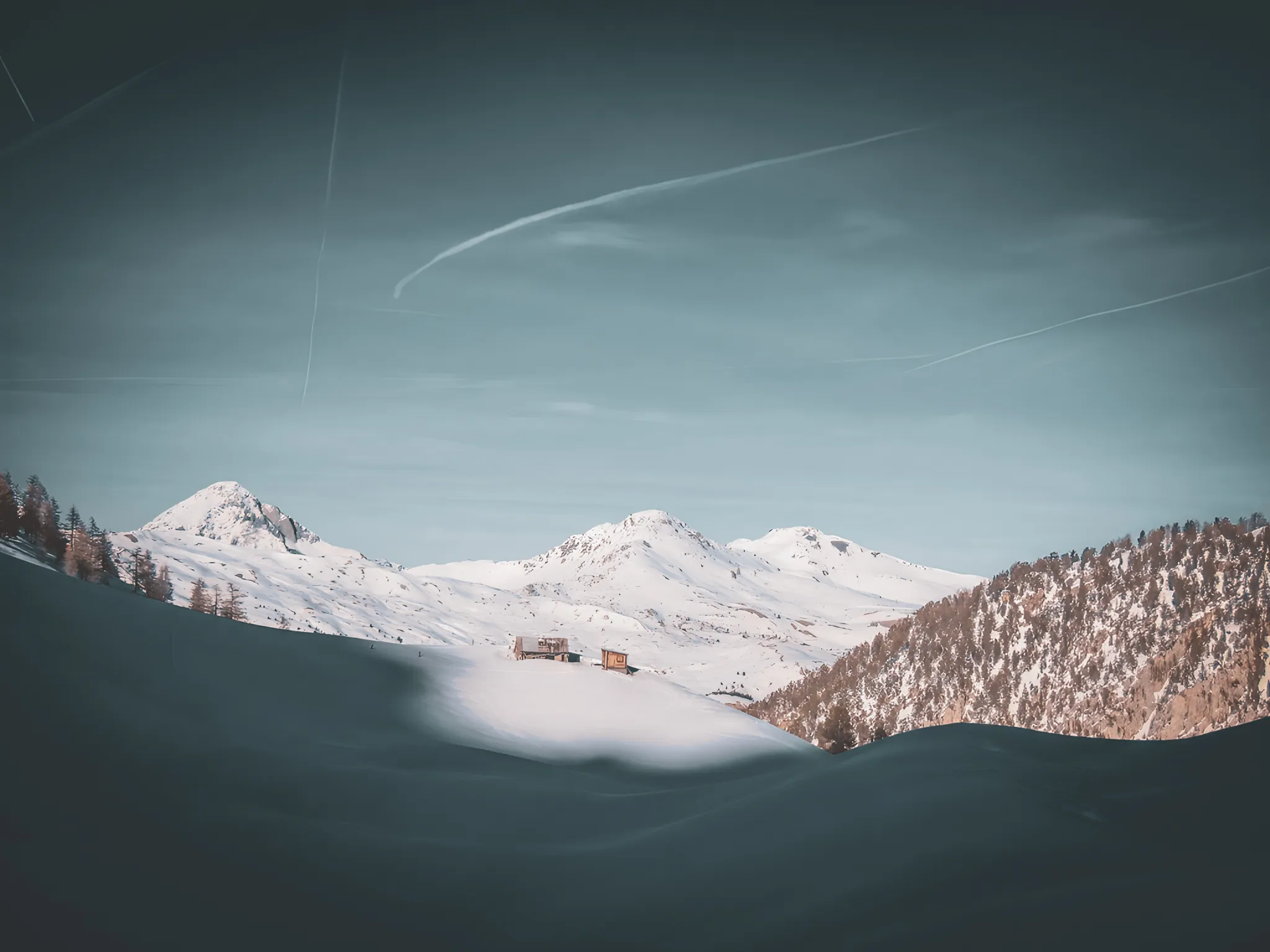 Breathtaking snow-covered landscapes between mountains and cosy chalets, an invitation to travel.