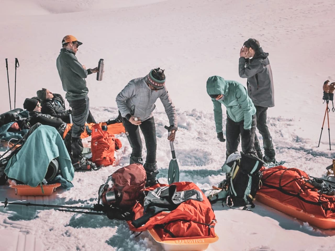 Een groep avonturiers op sneeuwschoenen, die samen een gezellig moment beleven midden in de natuur.