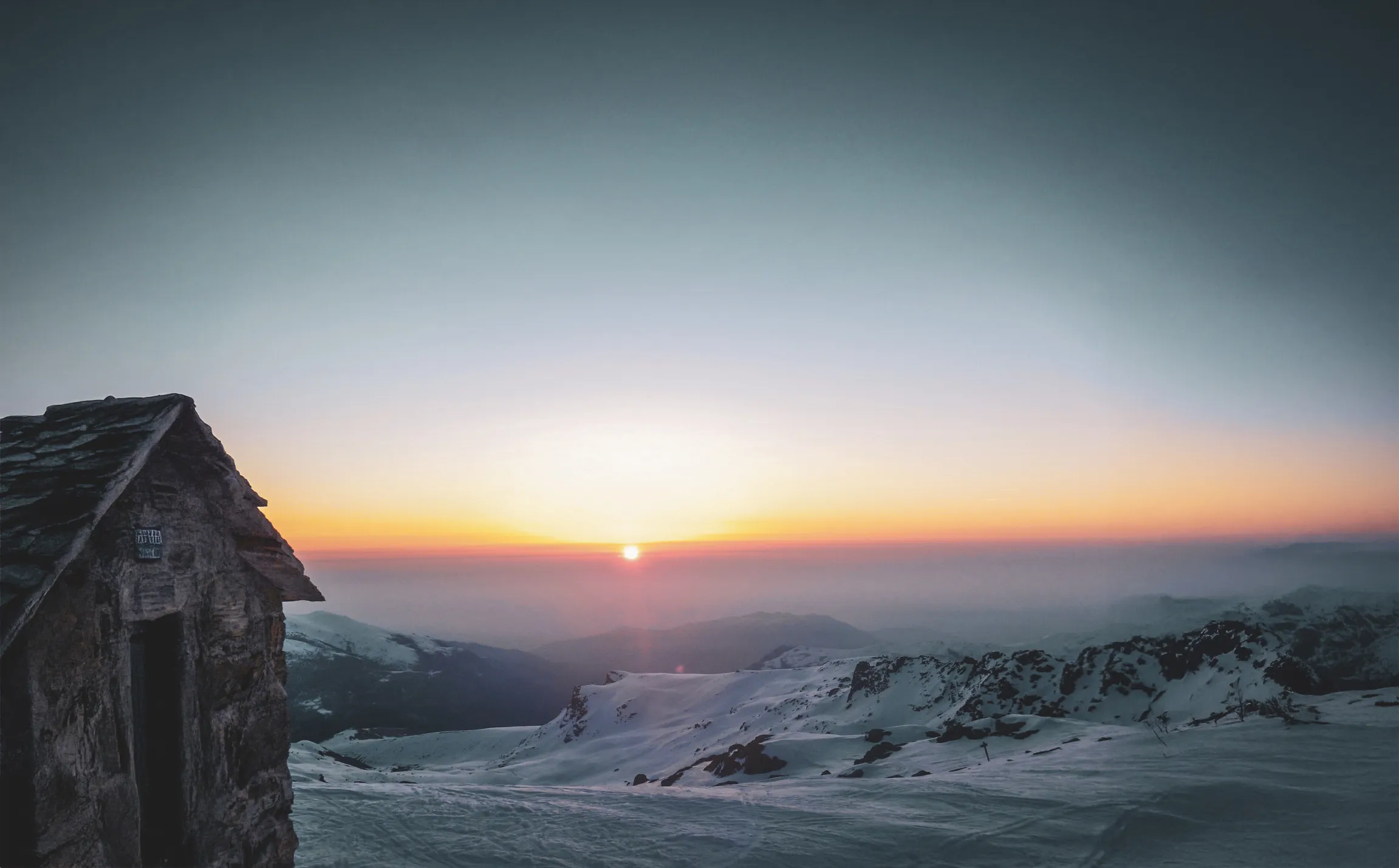 Coucher de soleil sur les montagnes enneigées, paisible et enchanteur.
