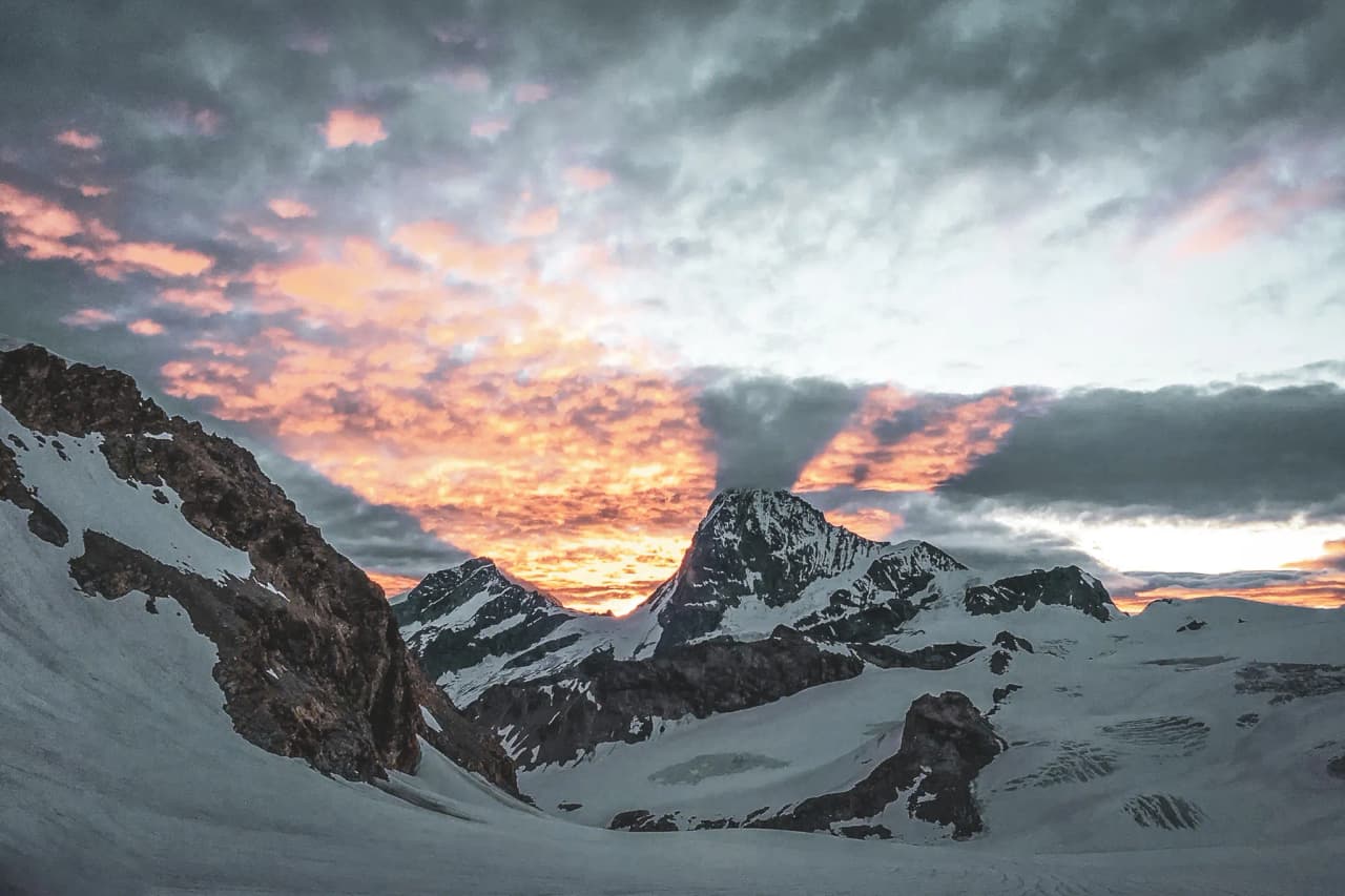 Spectacular sunrise over the snow-capped peaks of the Alps, ideal for a glacier adventure.