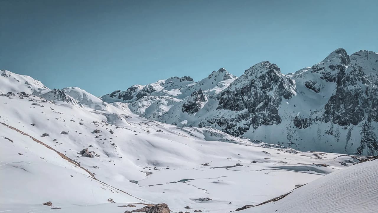 A snow-covered mountain landscape with majestic peaks, inviting you to embark on a winter adventure.