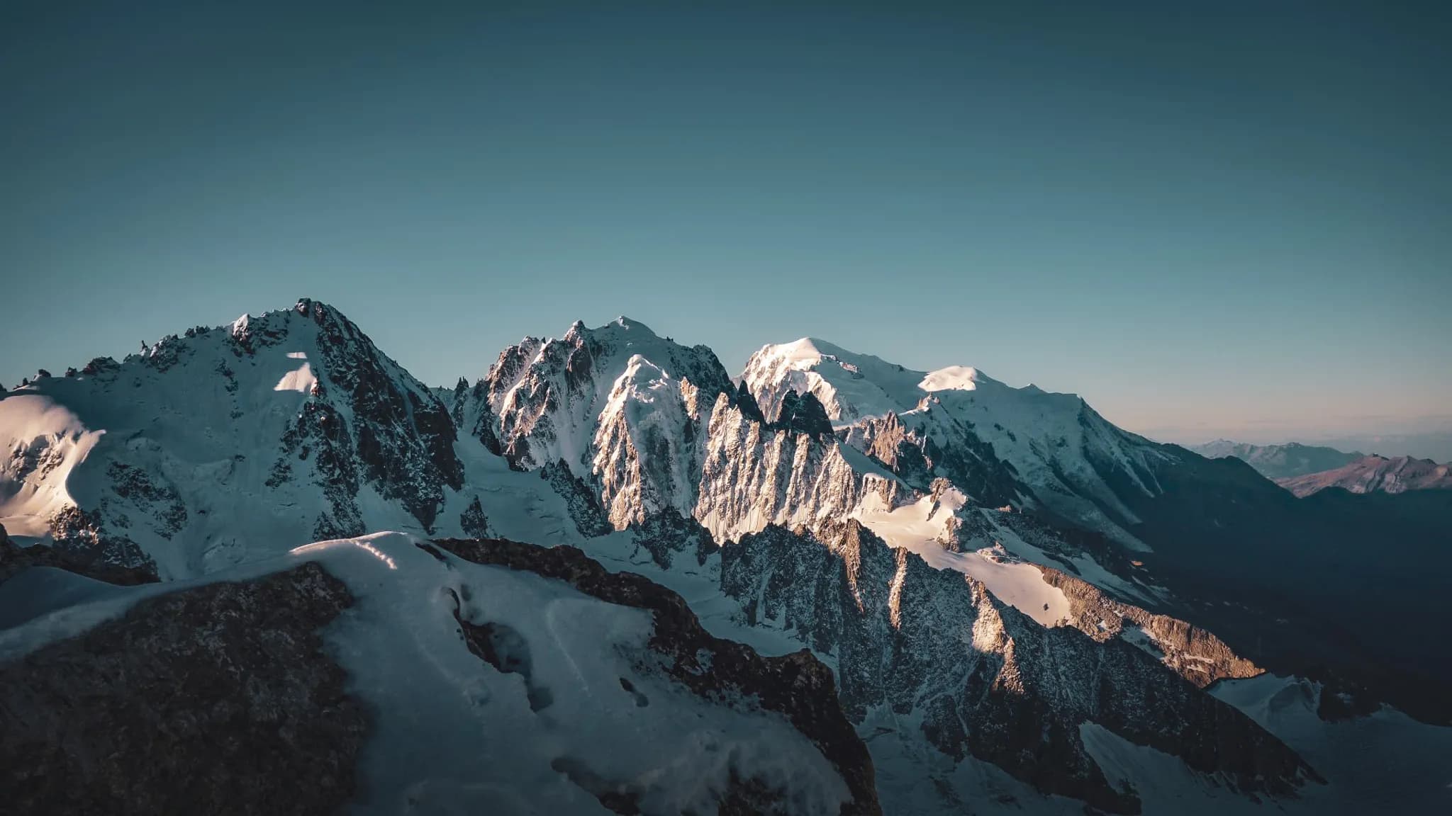 A majestic panorama of the Alps, snow-capped peaks and glaciers under a clear sky, an invitation to travel.