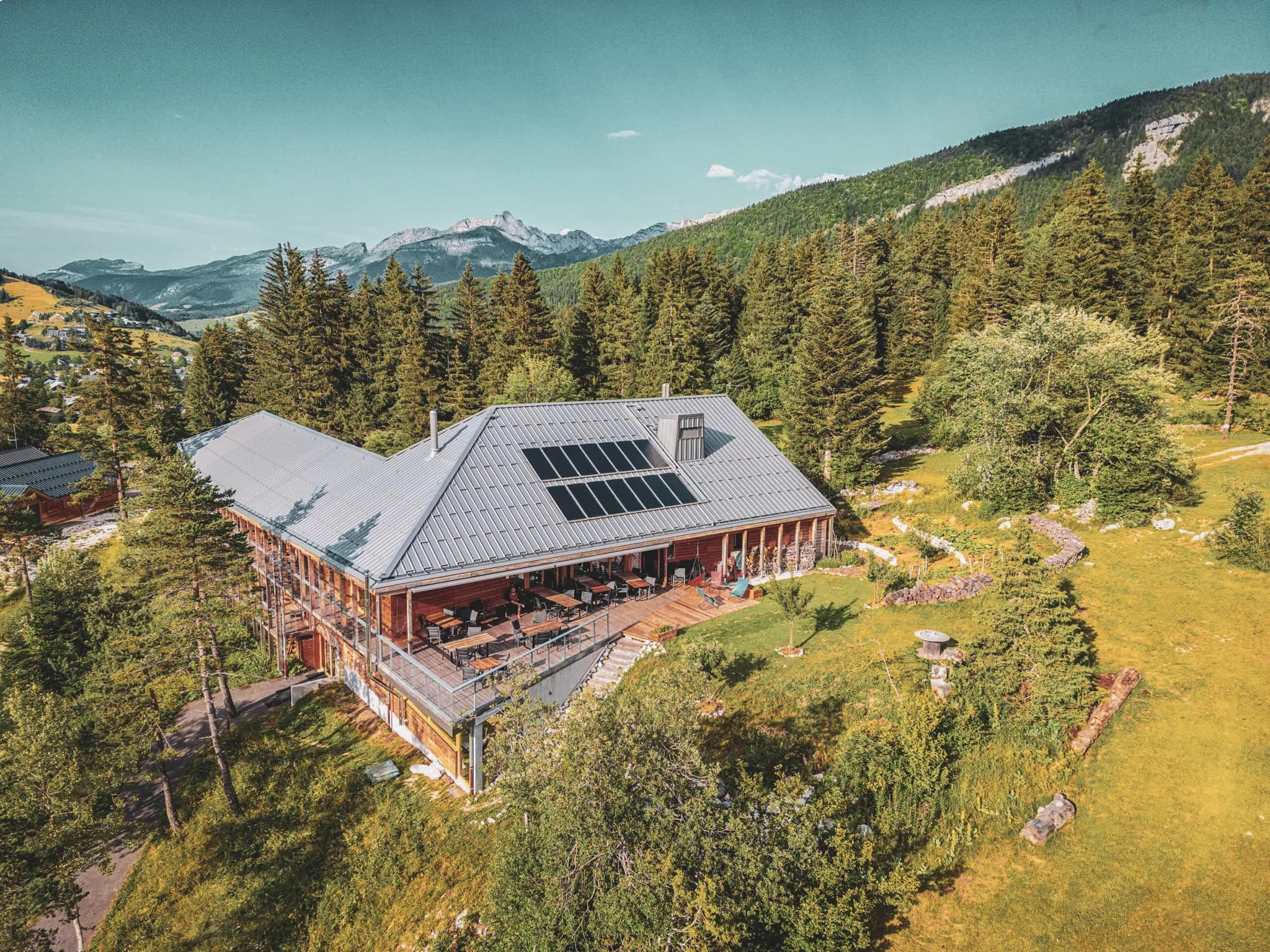 Houten chalet in het hart van de Vercors, omgeven door groen en een adembenemend landschap.