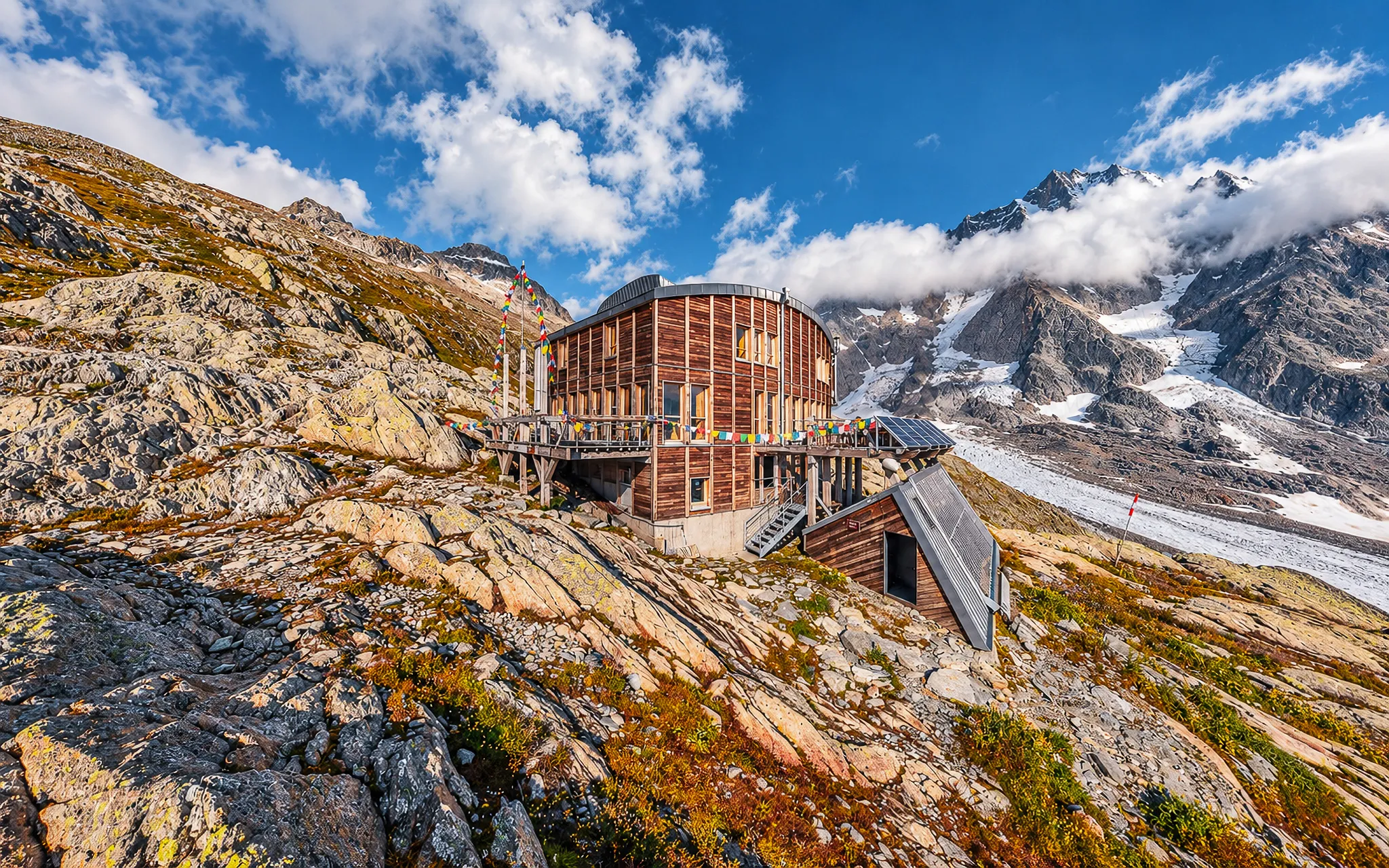 Een moderne Berghut met uitzicht op de majestueuze Dômes de Miage, omgeven door spectaculaire landschappen.