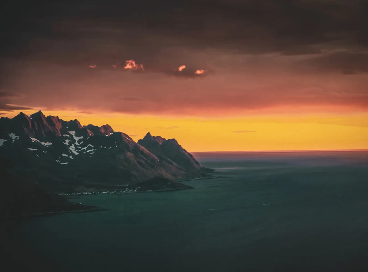 Oogverblindende zonsondergang over de bergachtige fjorden van het eiland Senja, Noorwegen.