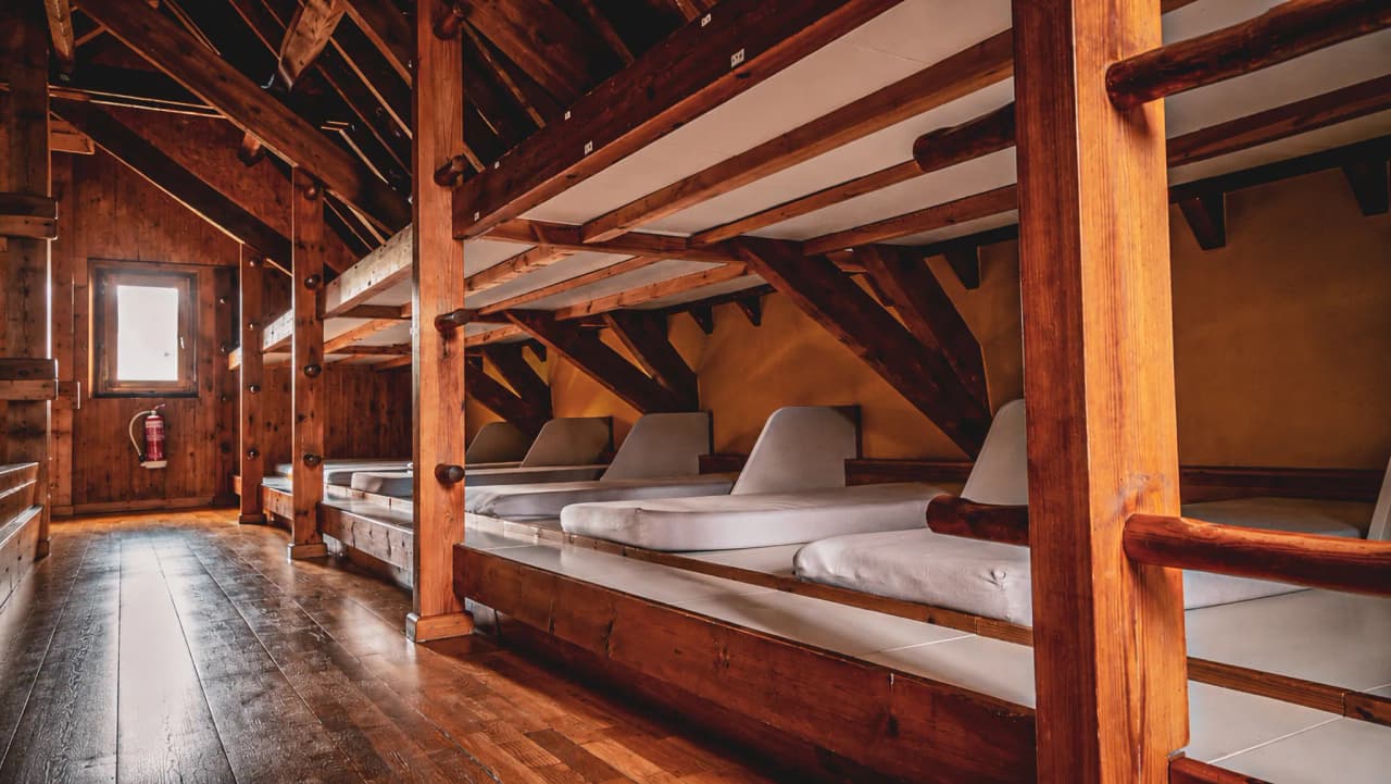 A cosy Mountain hut with wooden beds, perfect for recharging your batteries after a day's adventure.