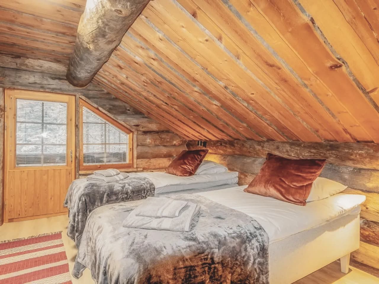 Chambre chaleureuse en bois avec lits douillets, idéale pour se reposer après l'aventure en Laponie.