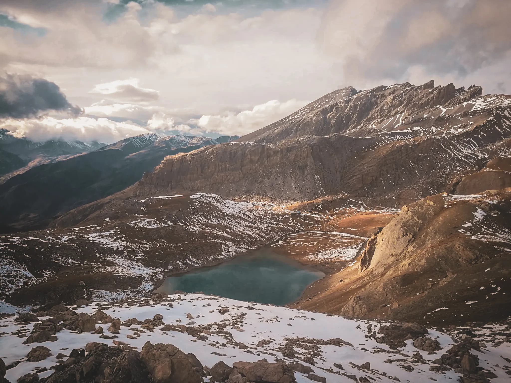 Een majestueus alpenlandschap met bergen, een turkooizen meer en sneeuw die uitnodigen tot avontuur.
