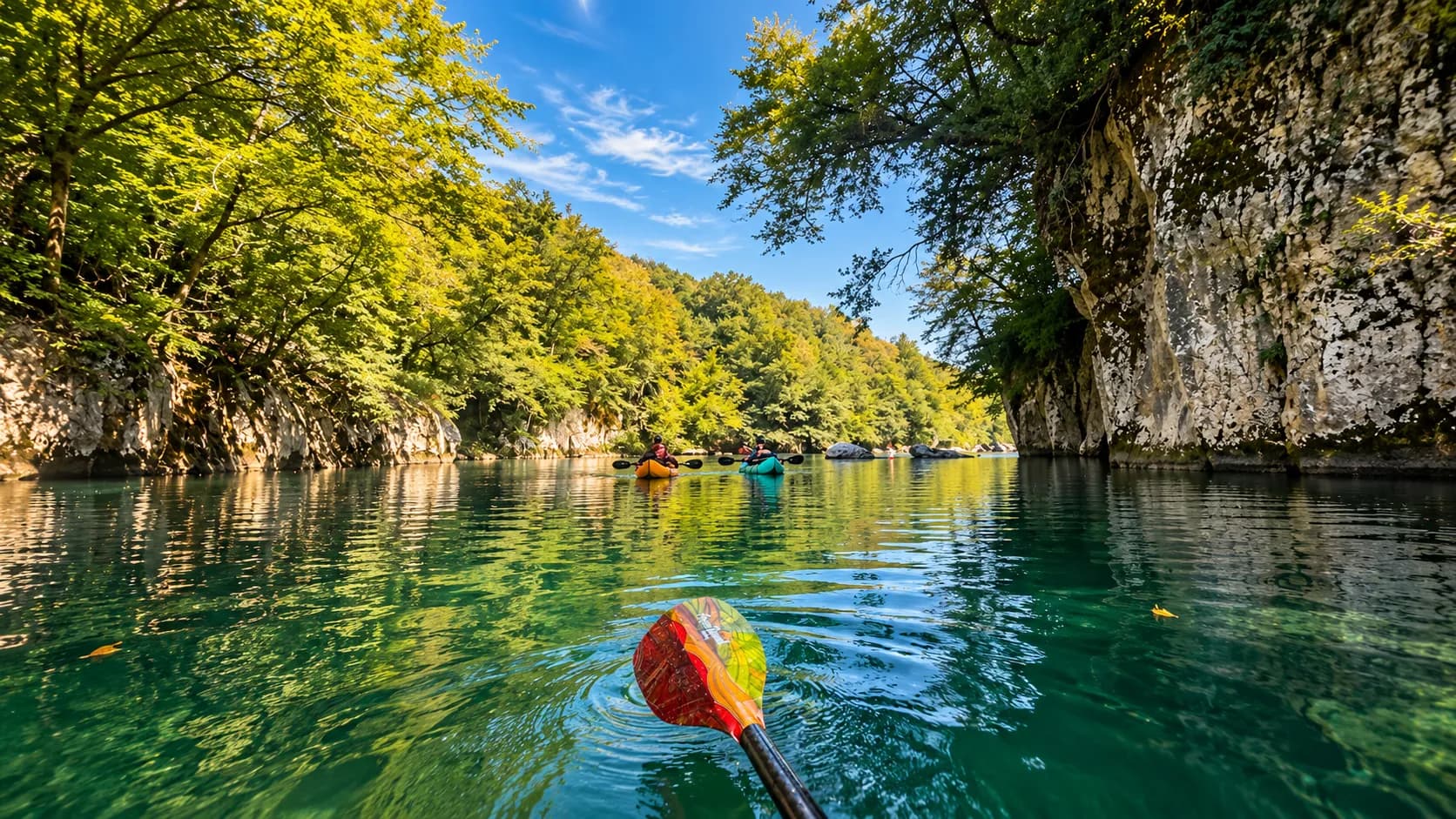 Pagaies colorées glissant sur une rivière émeraude, entourée de falaises verdoyantes en Slovénie.