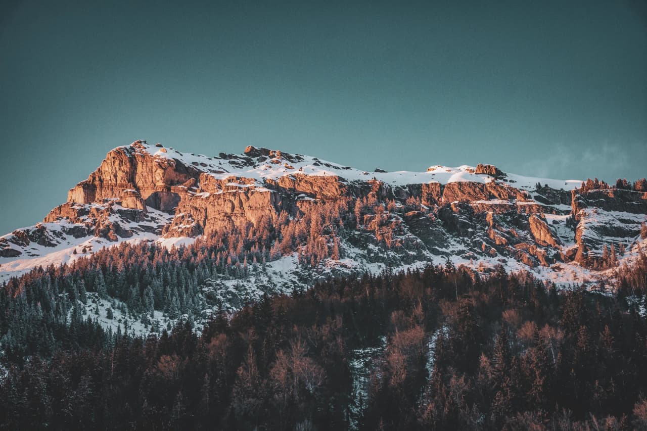 Majestueuse montagne enneigée sous un ciel clair, appelant à l'aventure alpine.