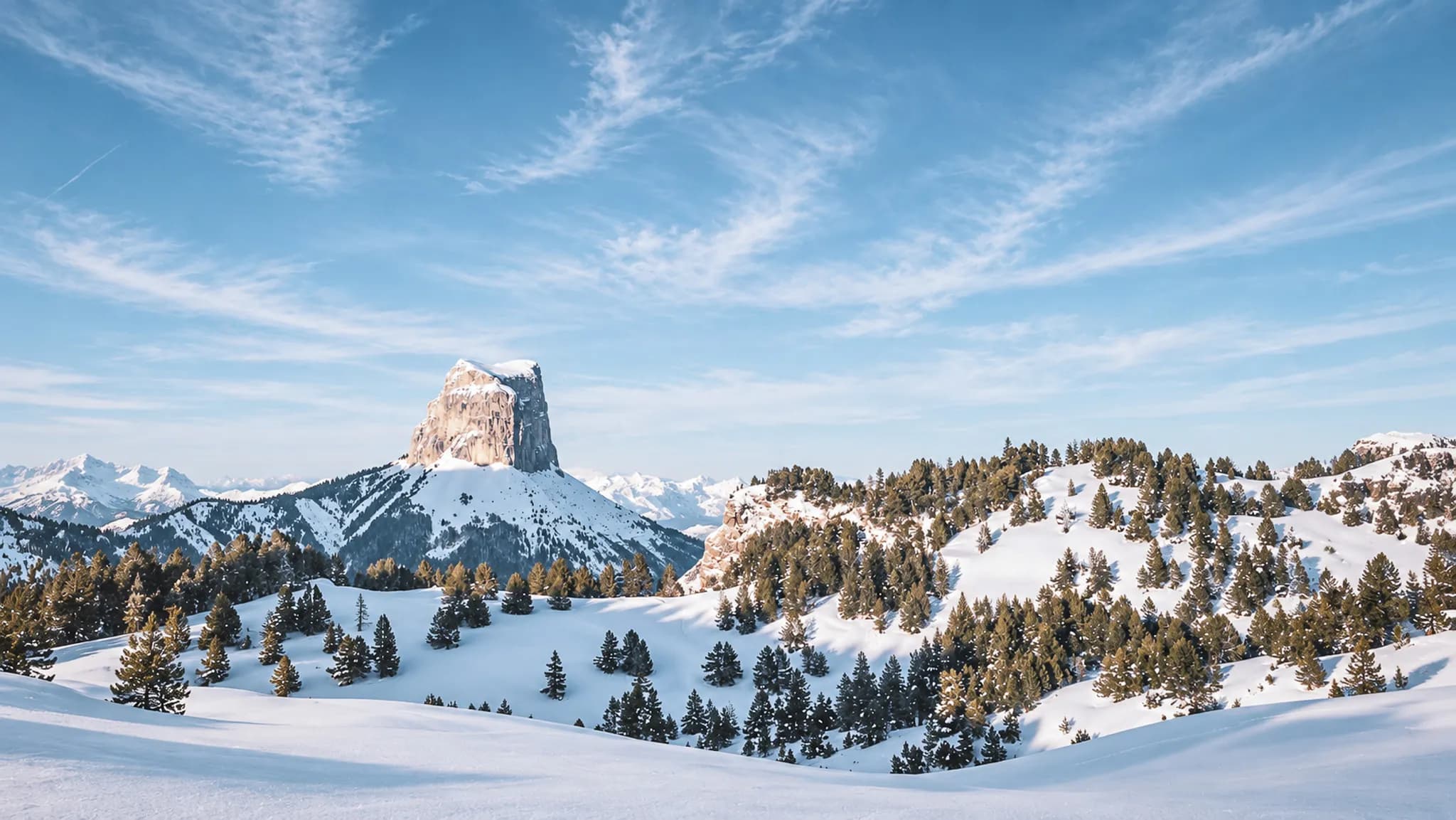 Vastes paysages enneigés du Vercors, magnificence du Mont Aiguille sous un ciel azur.