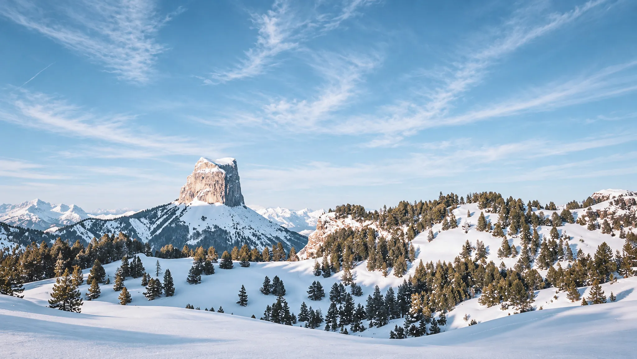 Vastes paysages enneigés du Vercors, magnificence du Mont Aiguille sous un ciel azur.