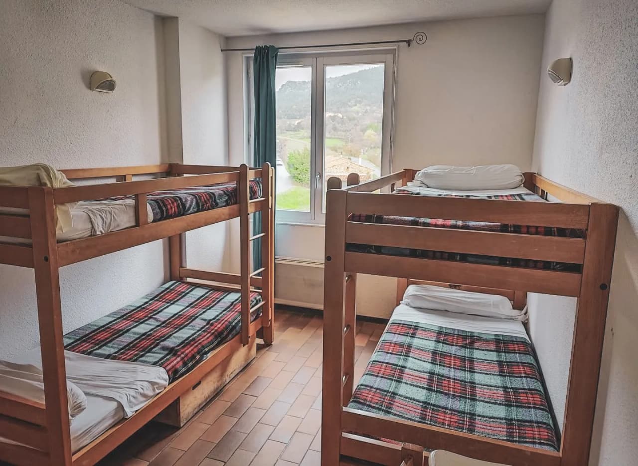 Bright room with bunk beds, offering a soothing view of the green countryside.