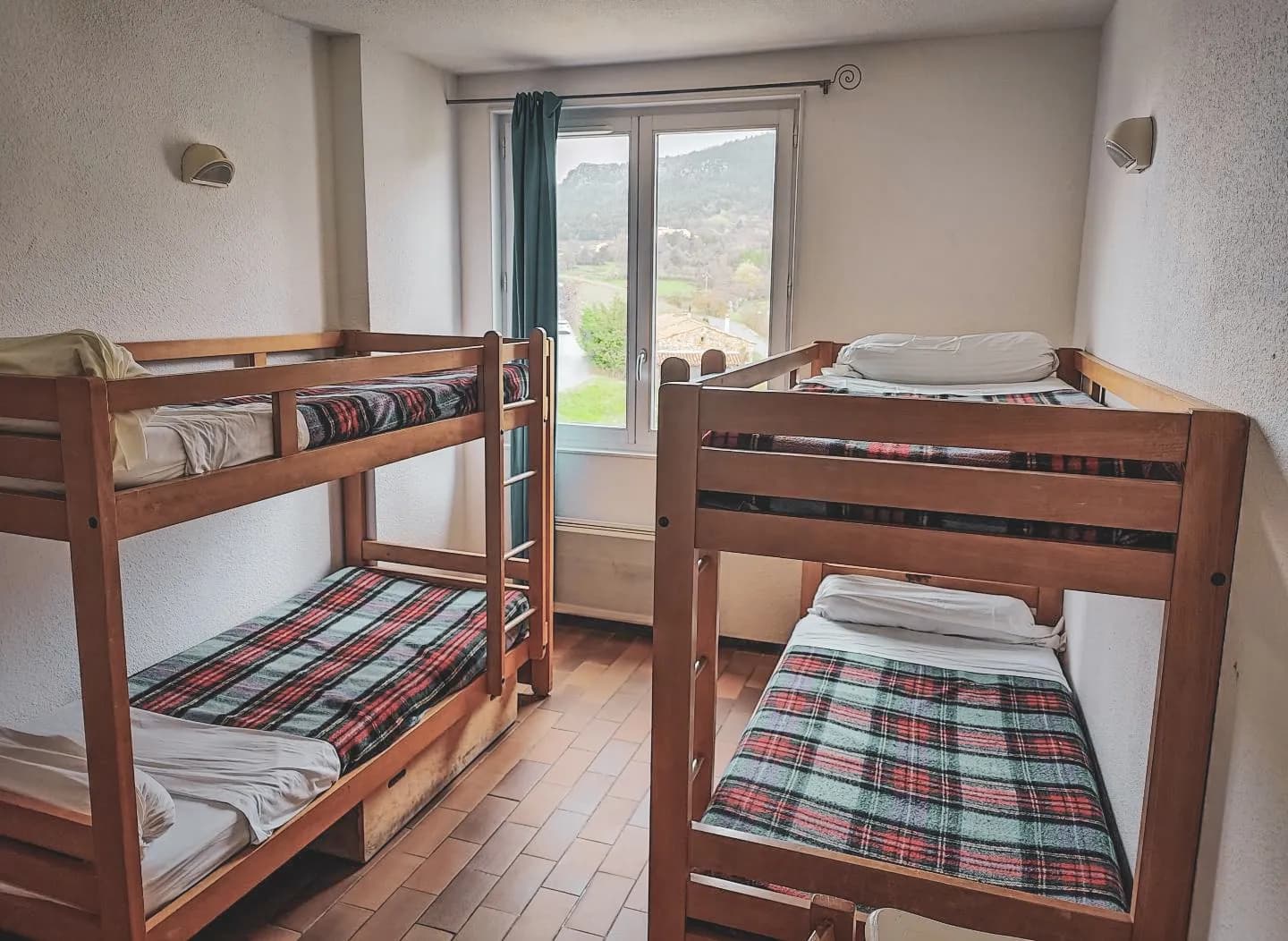 Bright room with bunk beds, offering a soothing view of the green countryside.