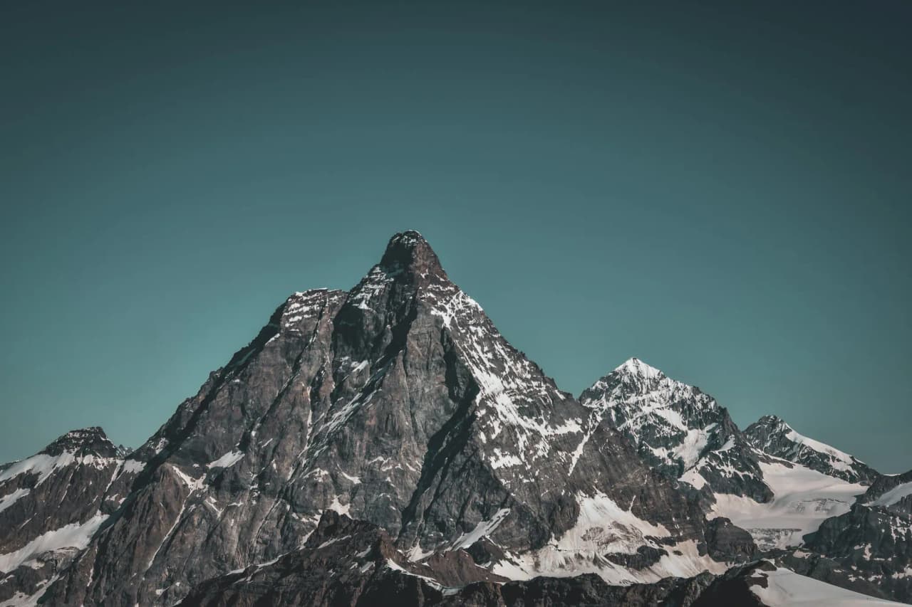 Majestueux sommet enneigé avec ciel azur, invitation à l'aventure alpine au Mont Rose.