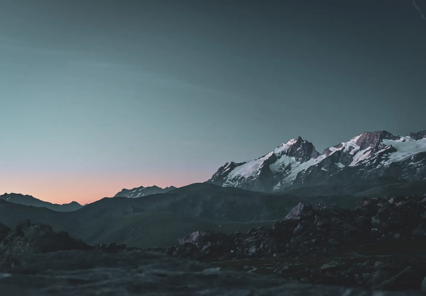 Coucher de soleil sur les montagnes enneigées, une invitation à l'aventure hivernale.