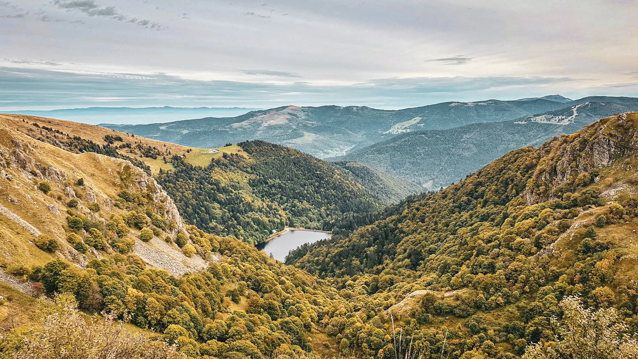 Vue panoramique des Vosges : vallées verdoyantes, lacs scintillants, nature préservée. Un paradis pour randonneurs !