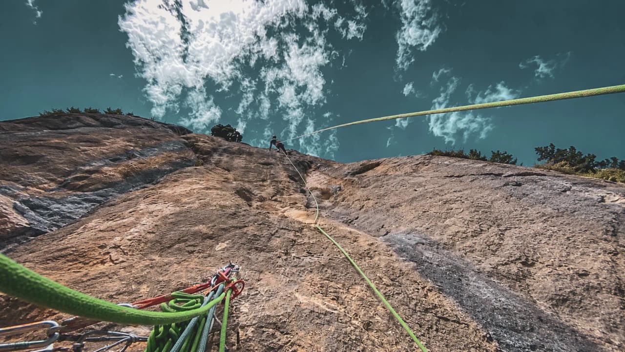 Klimmen in de Gorges du Verdon: indrukwekkend uitzicht op de rotswand en een bewolkte hemel.