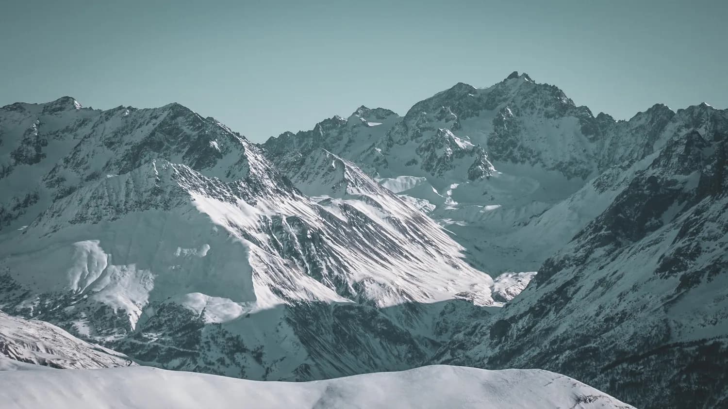 Snow-covered mountain scenery, majestic peaks, an invitation to ski touring adventure.
