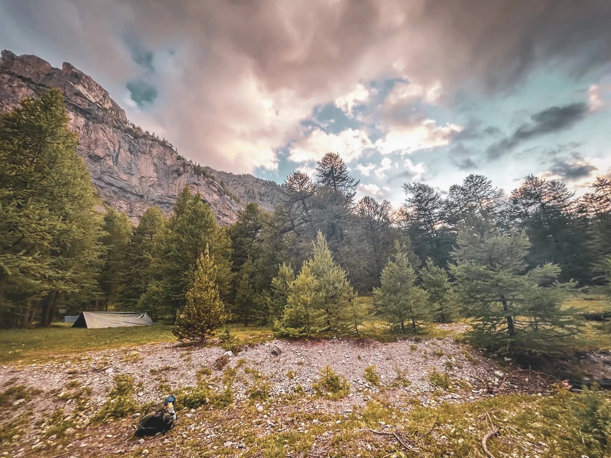 Een prachtig alpenlandschap, dichte bossen en bewolkte luchten, ideaal voor avontuur en bivak.