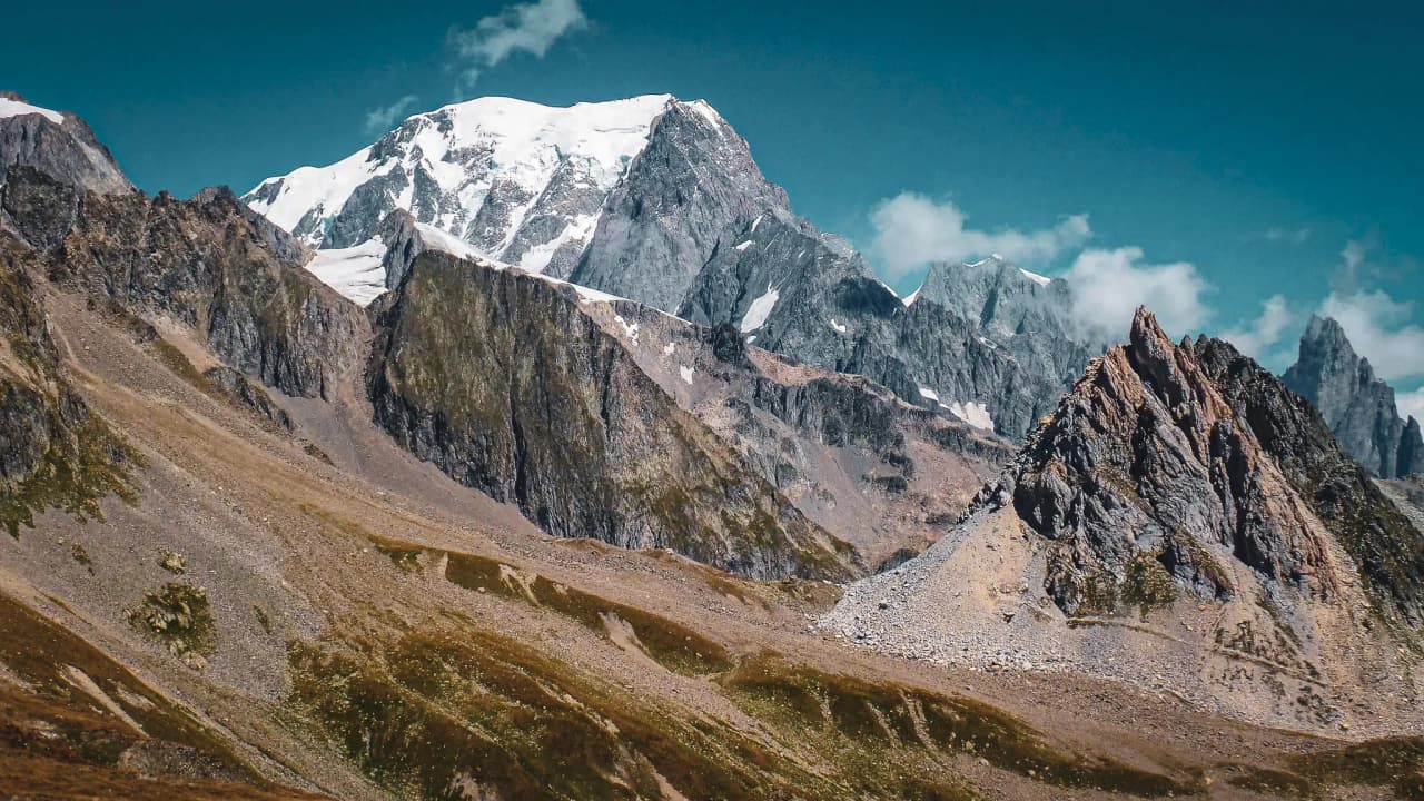 Majestic Alpine landscapes with snow-capped peaks and craggy rocks, an invitation to adventure.