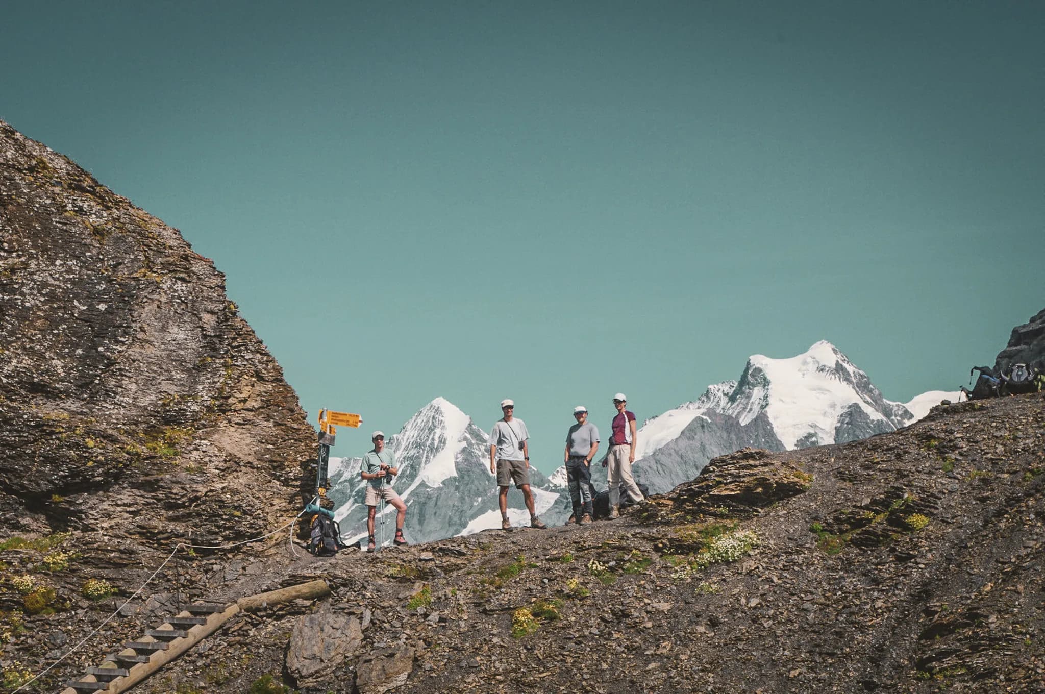 A group of hikers on the Aletsch glacier, with majestic peaks in the background.