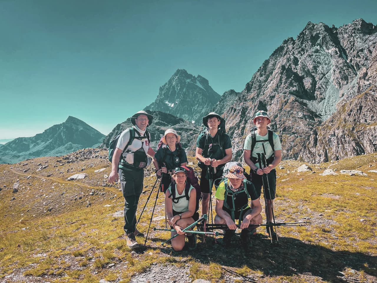 Een groep lachende wandelaars voor de majestueuze bergen van de Mont Viso.