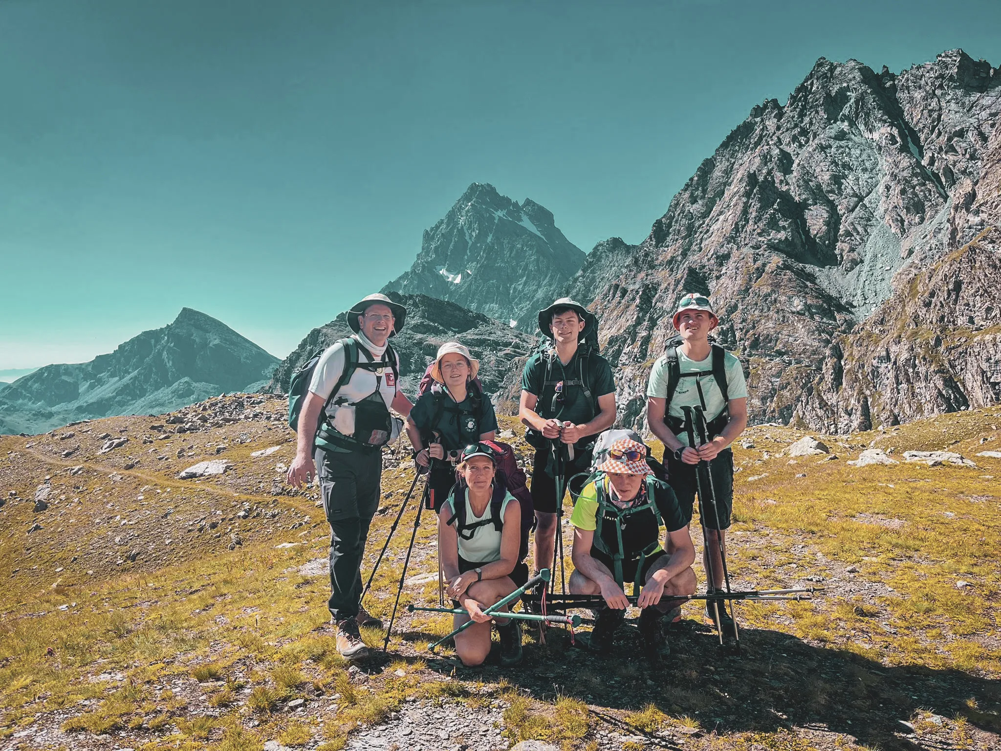 Groupe de randonneurs souriants devant des montagnes majestueuses au Mont Viso.