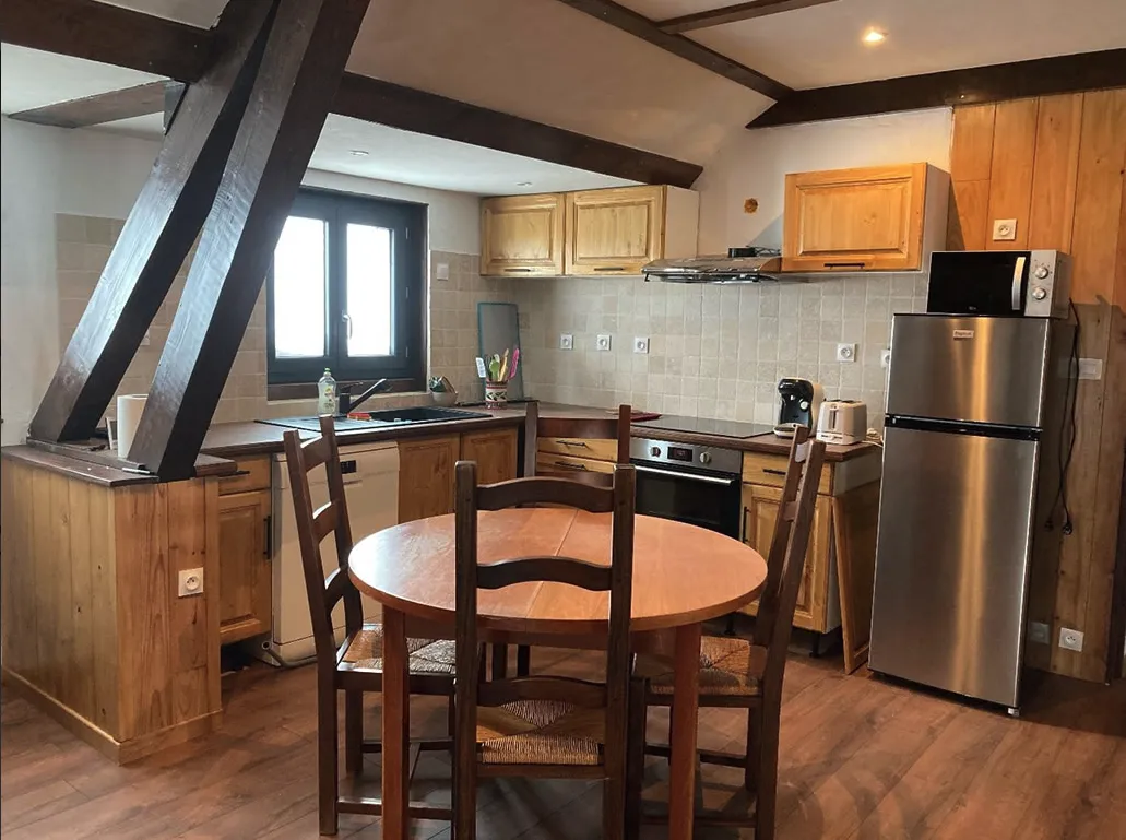 Cuisine chaleureuse en bois, table conviviale, parfait pour se retrouver après une journée en raquettes.
