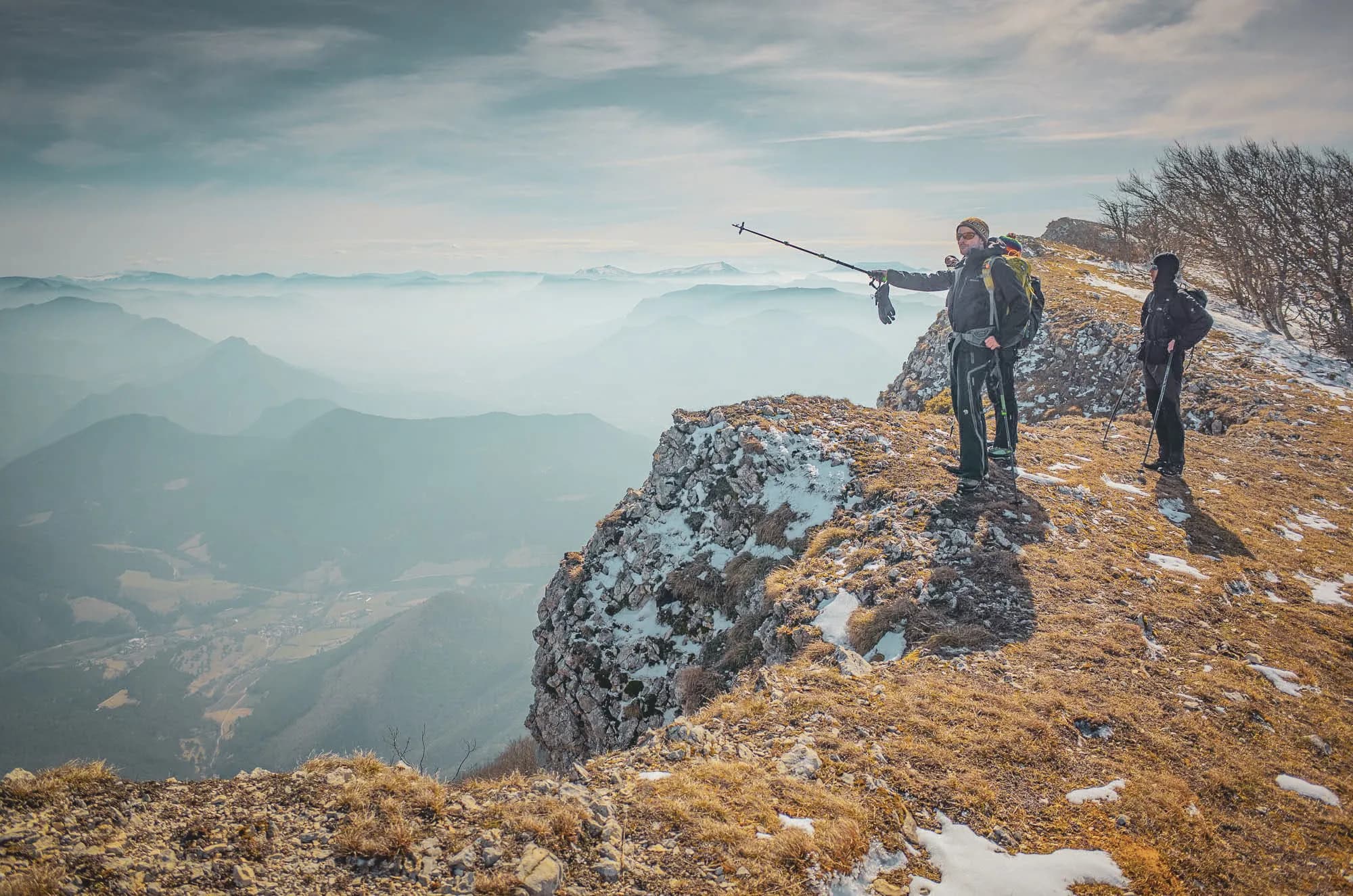 A group of adventurers on a snow-covered summit, admiring the majestic scenery of the Vercors.