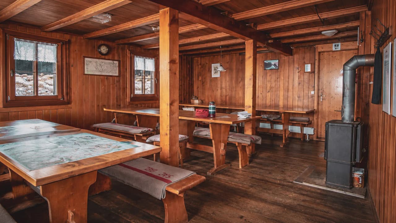 Intérieur chaleureux d'un refuge montagnard en bois, parfait pour se reposer après une randonnée.