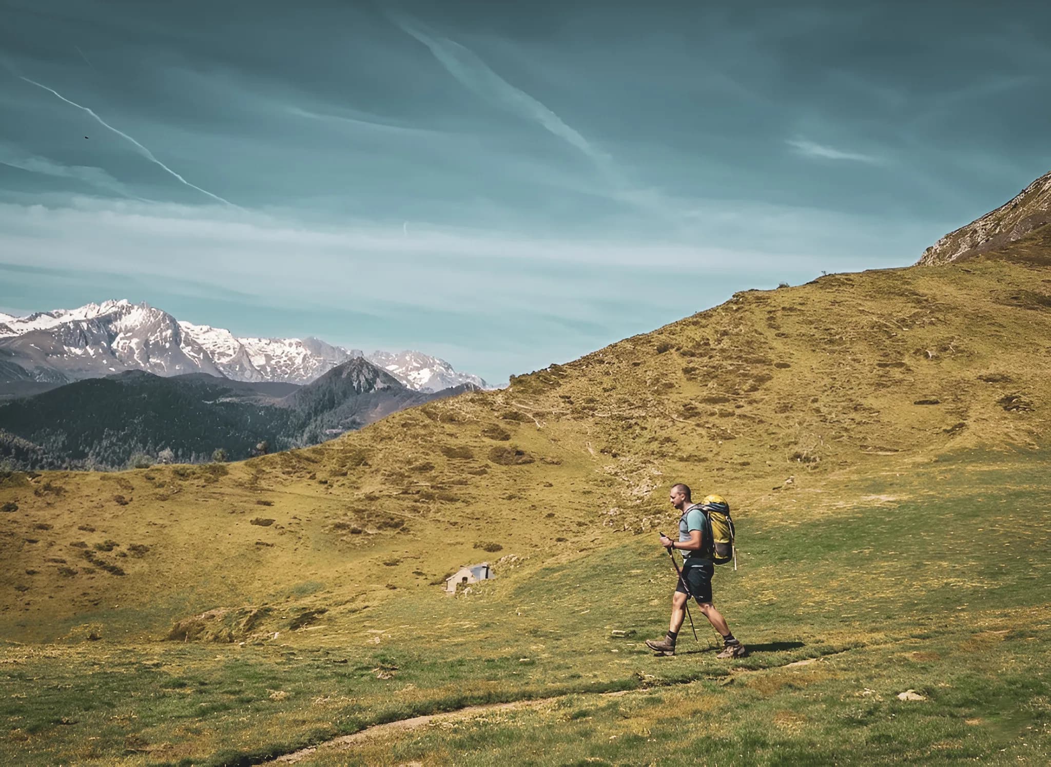 Wandelaars op een groen pad met besneeuwde bergen op de achtergrond, een uitnodiging tot avontuur.